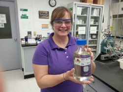 Elisha Cram, Research Engineer, FBRI Technology Research Center holding a diesel-cut of hydro treated UMaine TDO oil